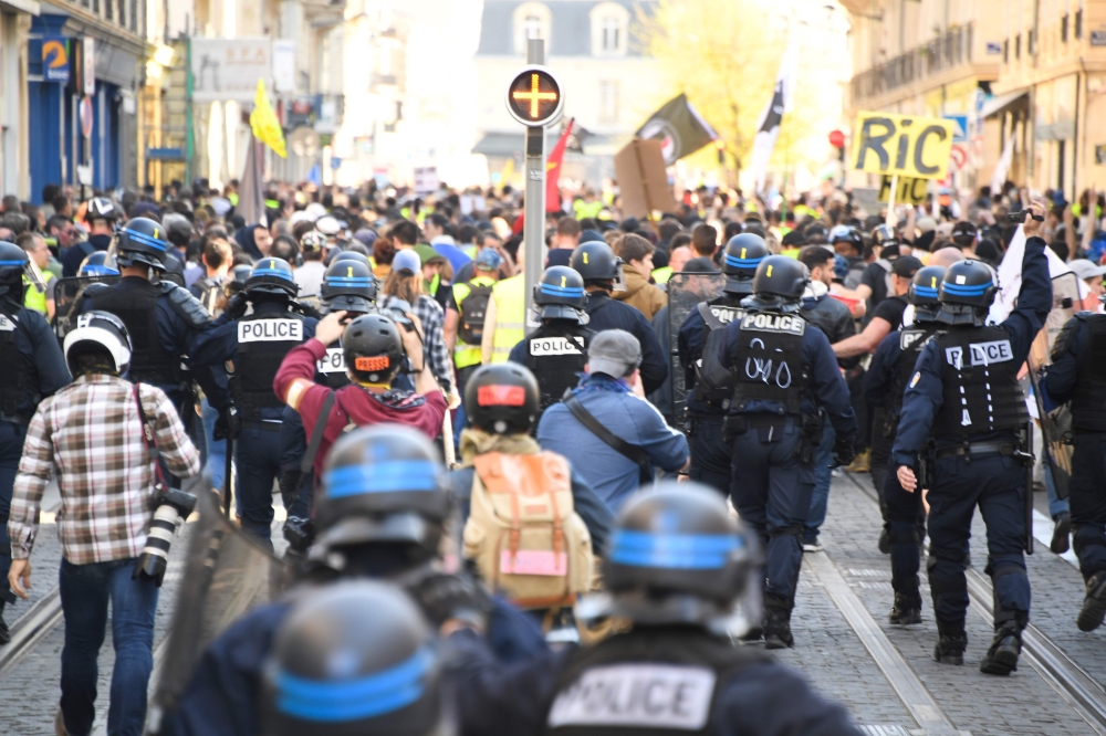 Anti-riot policemen walk behind 