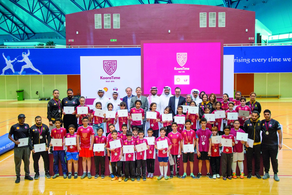 Qatar Football Association and Qatar Shell officials pose for a photograph with the award winning participants and coaches during the Koora Time Awards Ceremony held at the Aspire Dome in Doha, yesterday.