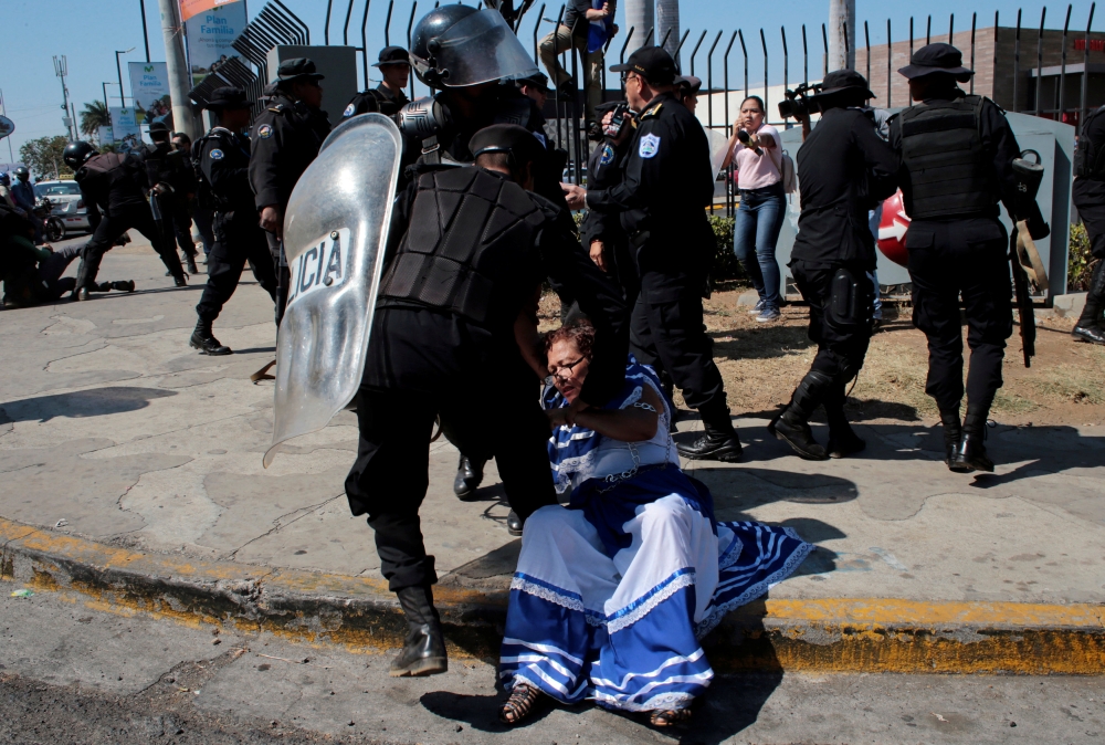 An anti-government protester in traditional costume is detained by riot police during a protest against the government of Nicaragua's President Daniel Ortega in Managua, Nicaragua March 30, 2019. REUTERS/Oswaldo Rivas