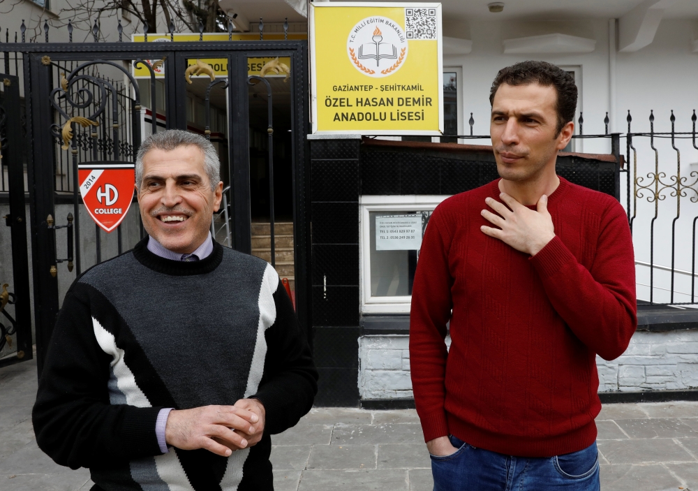 Jamal Sahlabji and his son Ahmed (R) stand in front of a private school in Gaziantep, Turkey, March 6, 2019. Picture taken March 6, 2019. Reuters/Umit Bektas