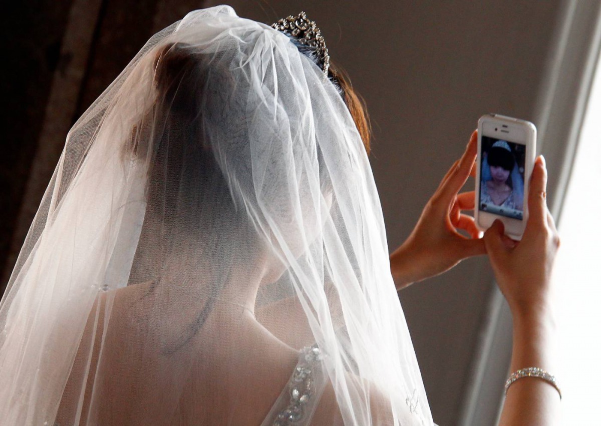 A Chinese bride takes a self portrait before her symbolic wedding in Fuessen May 31, 2012.  Reuters/Michael Dalder