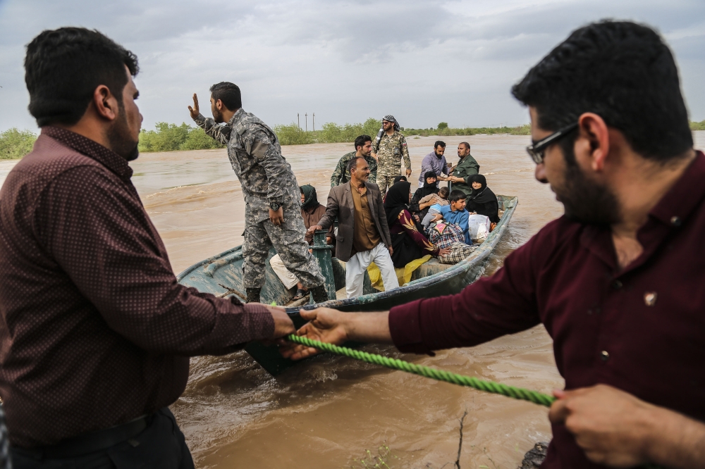 Iranian soldiers help civilians in a flooded area in a village around the city of Ahvaz, in Iran's Khuzestan province, on March 31, 2019. AFP / Tasnim News / Mehdi Pedramkhoo