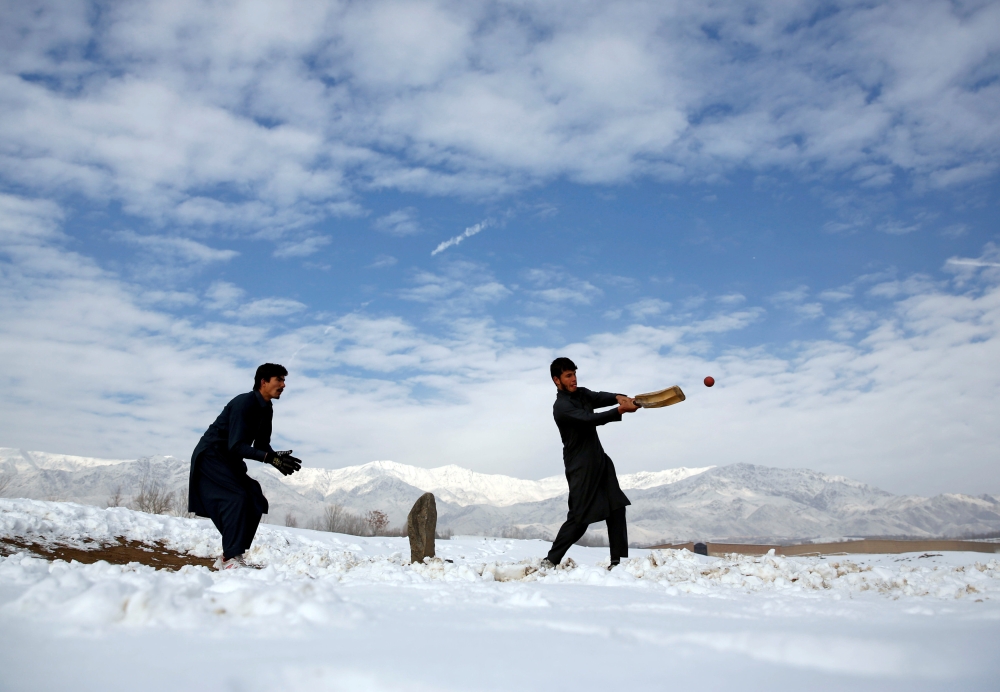 Afghan men play cricket on a field covered in snow on the outskirts of Kabul, Afghanistan December 16, 2017. Reuters/Mohammad Ismail