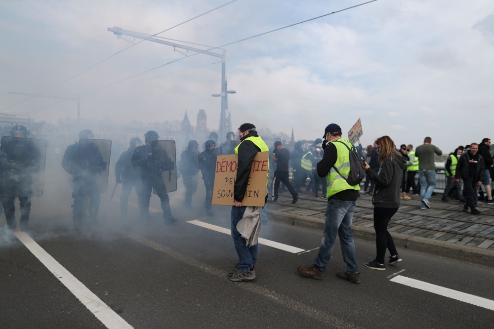 Protesters stand in front of French gendarmes during a 