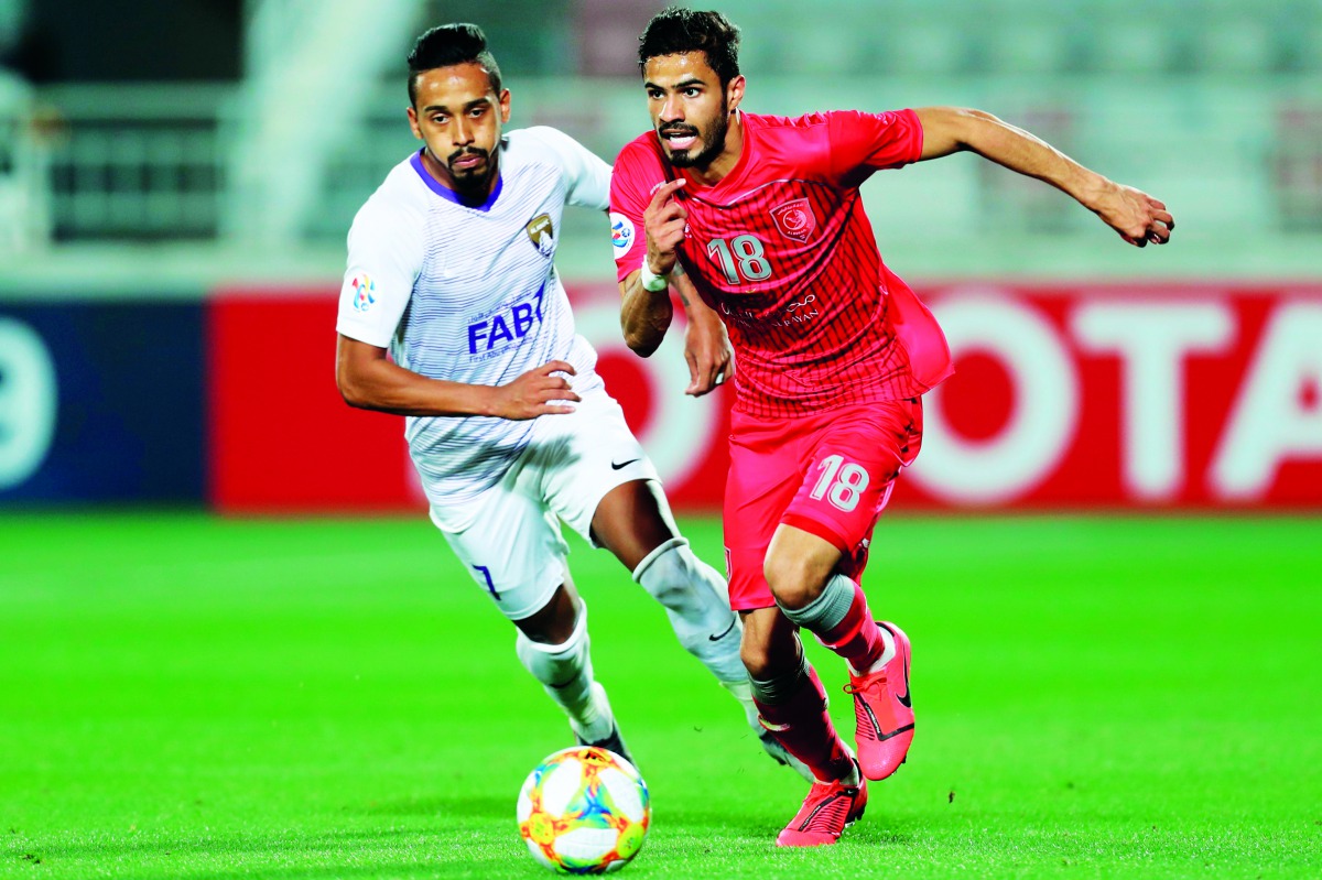 Al Duhail’s defender Sultan Al Brake (right) and Al Ain’s midfielder Caio vie for ball possession during the AFC Champions League Group C match at the Duhail Stadium in Doha, yesterday.