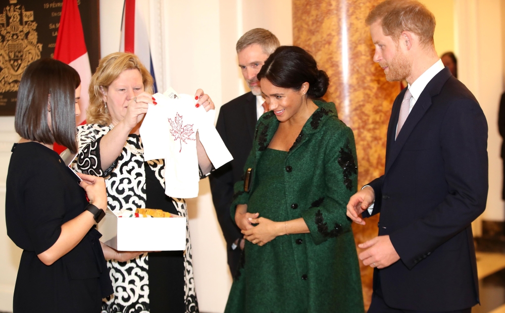 (FILES) In this file photo taken on March 11, 2019 Meghan, Duchess of Sussex (2R) and Britain's Prince Harry, Duke of Sussex (R), react as they are presented with baby gifts by Canadian High Commissioner to the United Kingdom, Janice Charette (2L), at Can