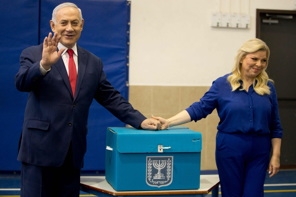 Israeli Prime Minister Benjamin Netanyahu (L) and wife Sara cast their ballot during Israel's parliamentary elections in Jerusalem, on April 9, 2019. AFP/Ariel Schalit 