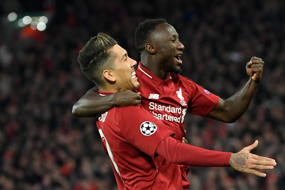 Liverpool's Guinean midfielder Naby Keita (R) celebrates with Liverpool's Brazilian midfielder Roberto Firmino after scoring a goal during the UEFA Champions League quarter-final, first leg football match between Liverpool and FC Porto at Anfield stadium 