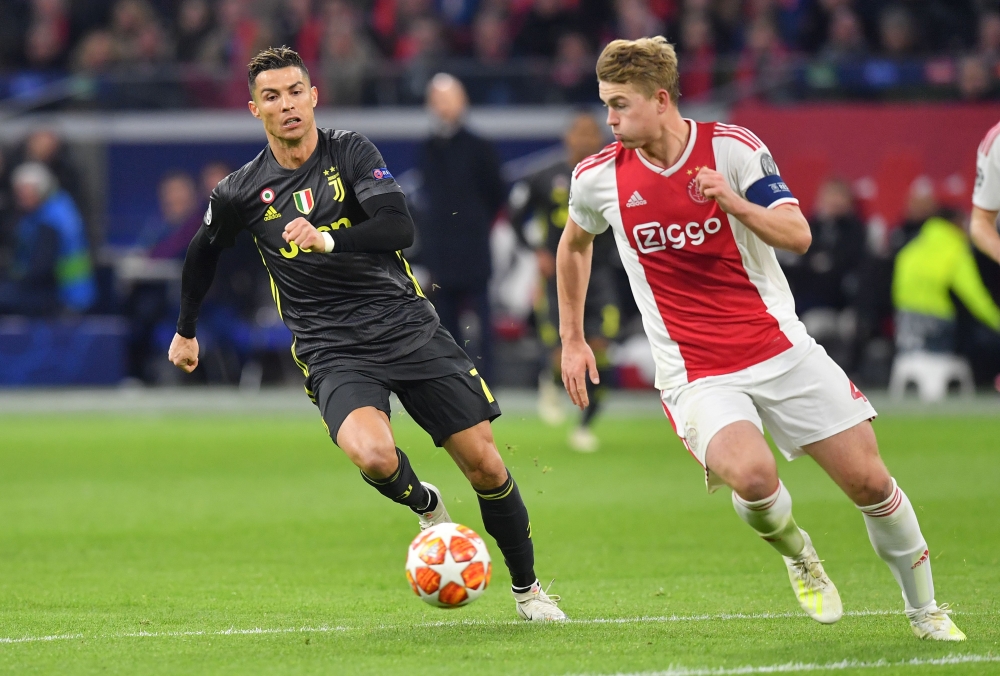 Juventus' Portuguese forward Cristiano Ronaldo (L) and Ajax's Dutch defender Matthijs de Ligt run with the ball during the UEFA Champions League first leg quarter-final football match between Ajax Amsterdam and Juventus FC at the Johan Cruijff ArenA in Am