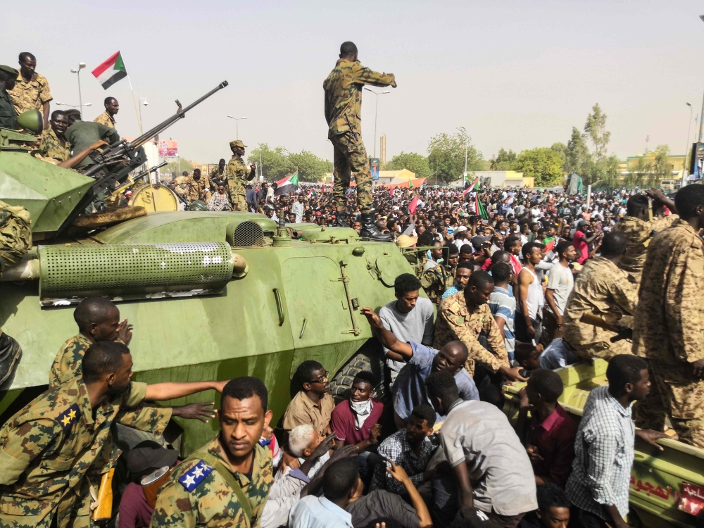 Sudanese soldeirs stand guard around armoured military vehicles as demonstrators continue their protest against the regime near the army headquarters in the Sudanese capital Khartoum on April 11, 2019.   AFP / -