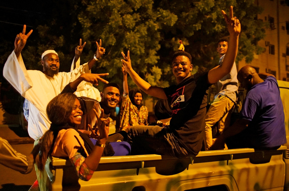 Sudanese demonstrators celebrate after the Defence Minister Awad Ibn Auf stepped down as head of the country's transitional ruling military council, as protesters demanded quicker political change, outside the Defence Ministry in Khartoum, Sudan April 13,