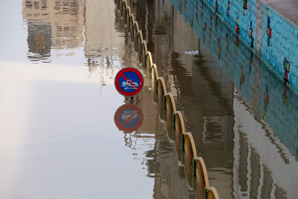This picture taken on April 11, 2019 shows a street sign partially submerged by water from floods in Ahvaz, the capital of Iran's southwestern province of Khuzestan Authorities ordered tens of thousands of residents of the southwestern Iranian city of Ahv