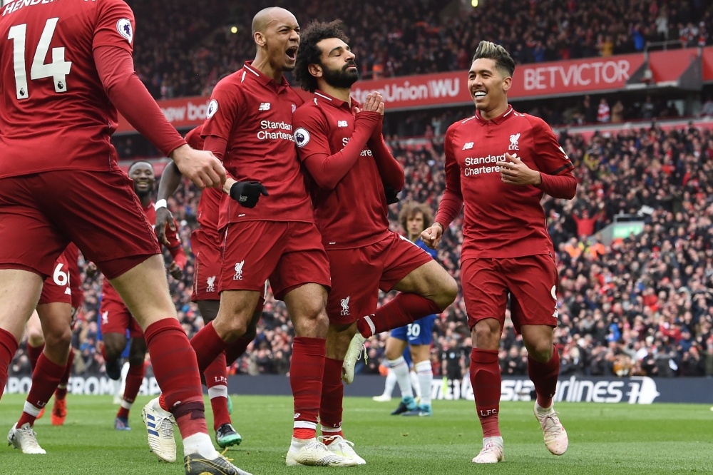 Liverpool's Egyptian midfielder Mohamed Salah (C) celebrates with teammates after scoring their second goal during the English Premier League football match between Liverpool and Chelsea at Anfield in Liverpool, north west England on April 14, 2019. AFP /