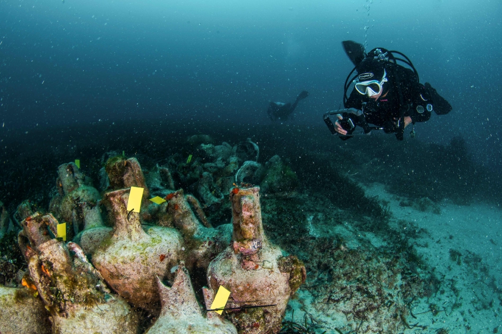 This undated handout photo released on April 9, 2019 shows divers exploring the ruins of an ancient shipwreck on the Aegean island of Alonissos, Greece.  AFP / Ephorate of Underwater Antiquities 