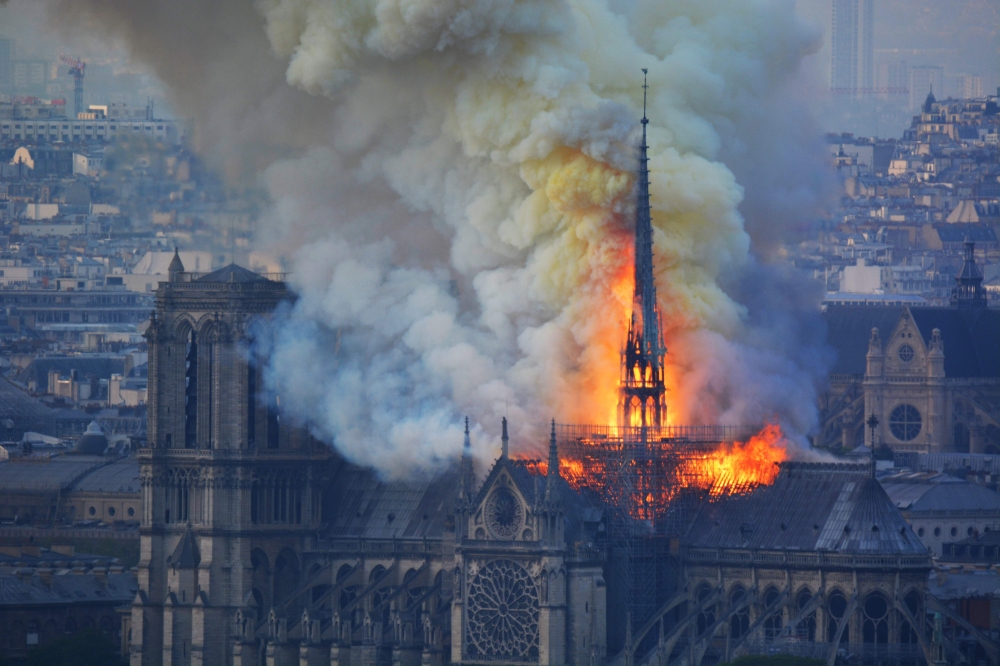  Smoke and flames rise during a fire at the landmark Notre-Dame Cathedral in central Paris on April 15, 2019, potentially involving renovation works being carried out at the site, the fire service said. / AFP / Hubert Hitier
 