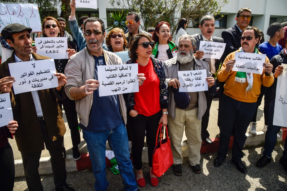 Algerian artists chant slogans as they protest against the government as they call for more liberties during a sit-in outside the Ministry of Culture headquarters in the capital Algiers on April 17, 2019.  AFP / Ryad Kramdi 