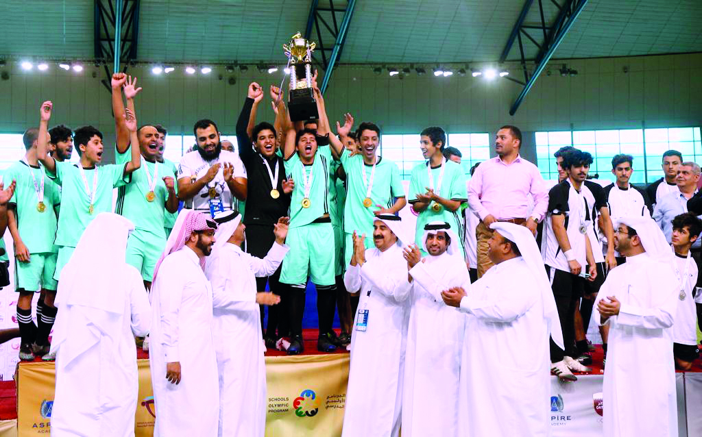 The players and officials of Ibn Taymiyyah Independent Secondary School celebrate with the trophy as officials applaud them after the final at Aspire Dome, yesterday. 