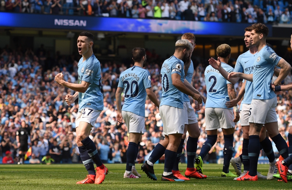 Manchester City's English midfielder Phil Foden (L) celebrates scoring the opening goal during the English Premier League football match between Manchester City and Tottenham Hotspur at the Etihad Stadium in Manchester, north west England, on April 20, 20