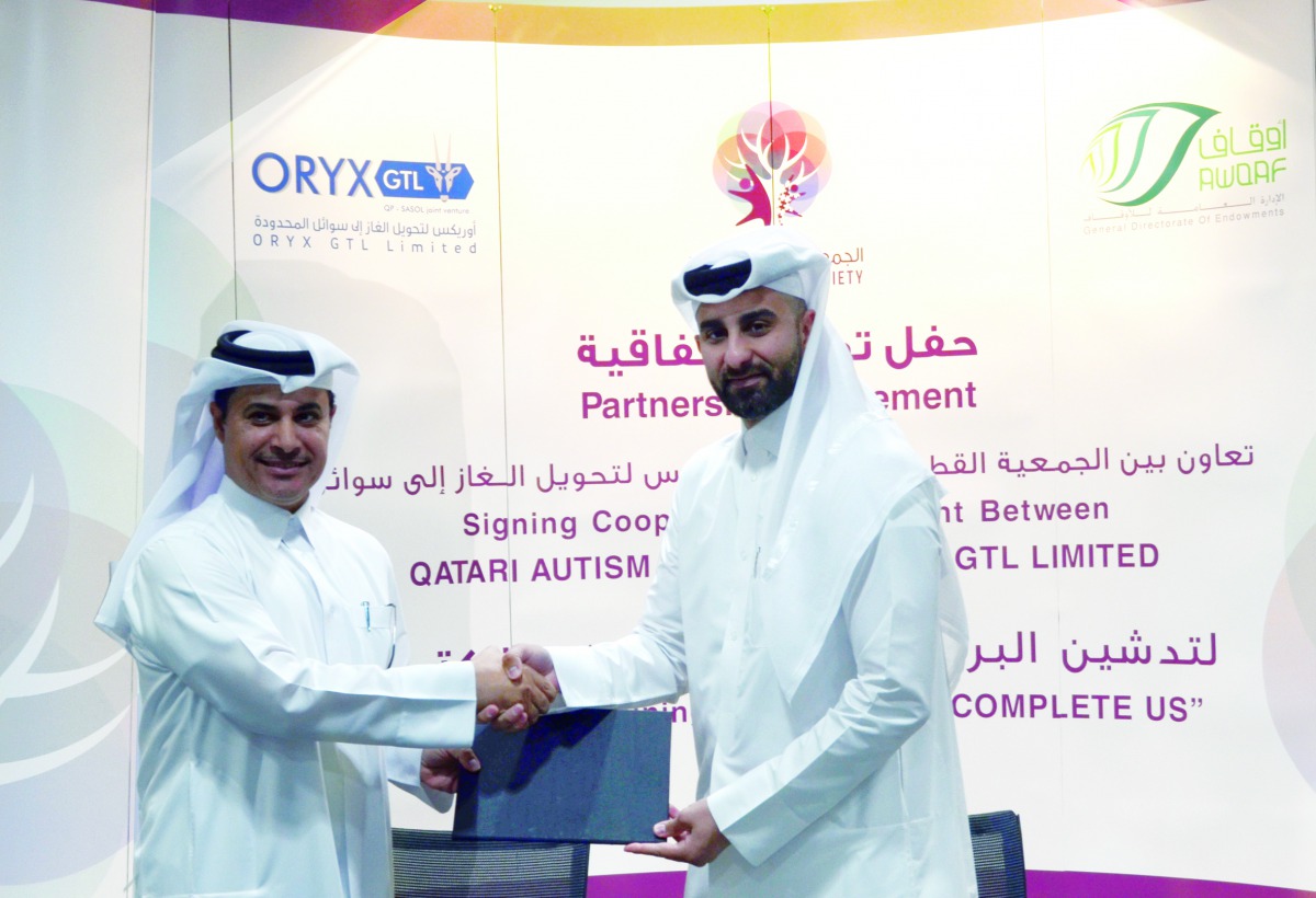 The officials of QAS and ORYX GTL exchanging documents after signing the agreement.