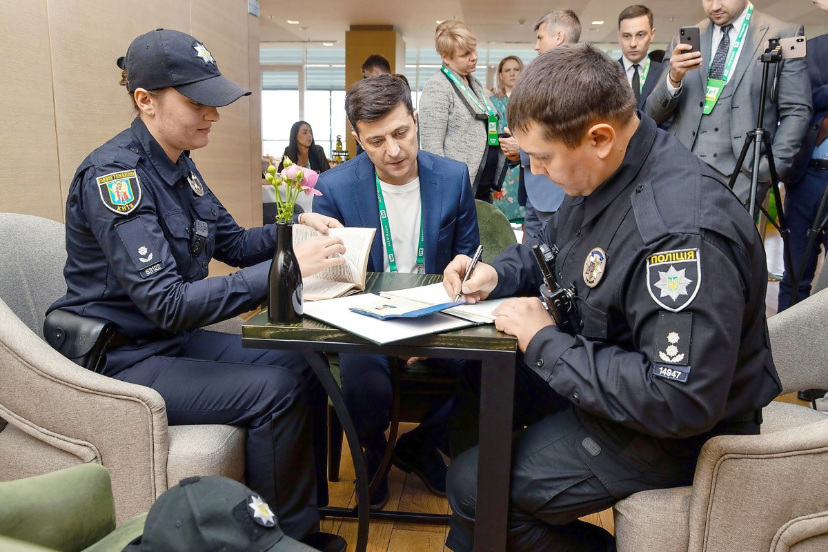 Volodymyr Zelensky being fined by police for showing his marked ballot paper to the public at a polling station in Kiev on April 21, 2019 thus violating the voting rules protocol.  AFP/Volodymyr Zelensky press service handout