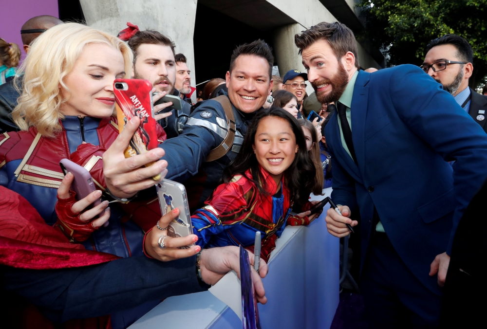 Cast member Chris Evans poses with fans on the red carpet at the world premiere of the film 
