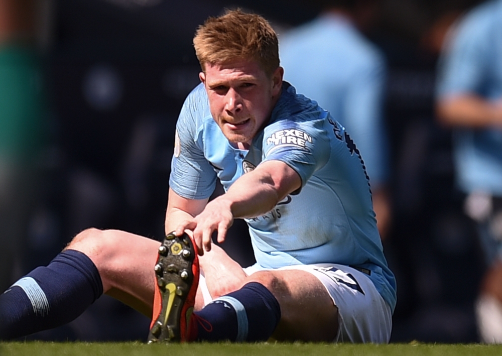 Manchester City's Belgian midfielder Kevin De Bruyne stretches on the ground after picking up an injury and before being substituted during the English Premier League football match between Manchester City and Tottenham Hotspur at the Etihad Stadium in Ma
