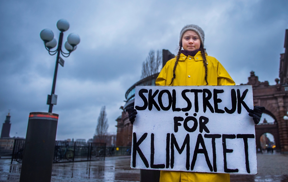 15-year-old Greta Thunberg holds a placard reading 'School strike for the climate' outside the Swedish parliament in Stockholm, Nov 30, 2018. TT News Agency/Hanna Franzen/Reuters