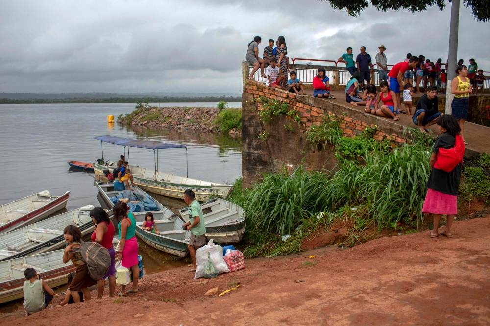 Indigenous people prepare their boats at a improvised harbor used as access to indigenous lands that are only reachable by boat or plane in the Amazonian rainforest, in Altamira, Para state, Brazil on March 12, 2019.  AFP / Mauro Pimentel