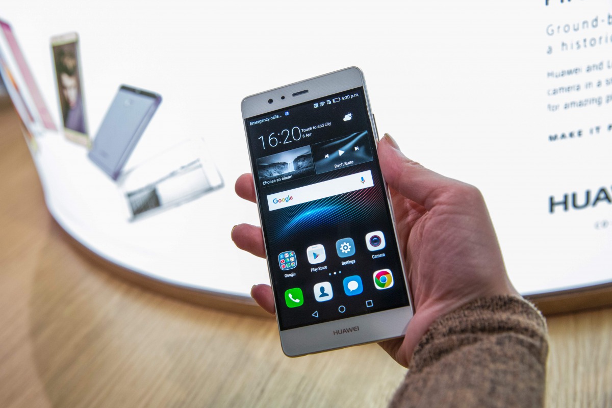 A woman poses holding P9 smartphone by Chinese tech company Huawei during the launch at Battersea Evolution in London on April 6, 2016. AFP/Jack Taylor
