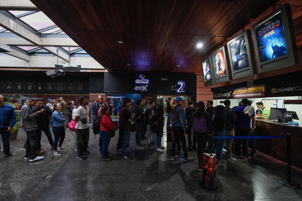 Venezuelan filmgoers queue to withdraw tickets to watch the first screening in Venezuela of Marvel Studios' 