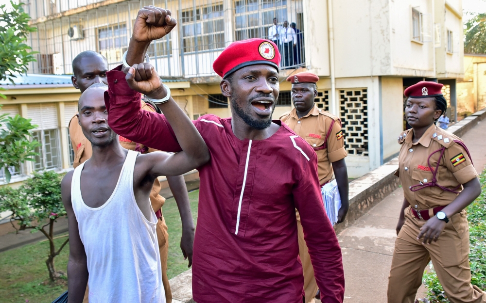 Opposition figurehead Hon Kagulanyi Robert aka Bobi Wine walks handcuffed together with another prisoner before boarding the prison bus leading him to Luzira maximum prison in Kampala on April 29, 2019.  AFP / Nicholas Bamulanzeki
 