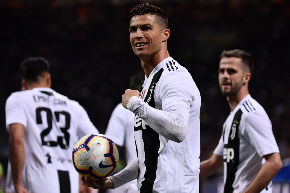 Juventus' Portuguese forward Cristiano Ronaldo (C) celebrates after scoring a goal during the Italian Serie A football match between Inter Milan and Juventus on April 27, 2019 at the San Siro stadium in Milan. / AFP / MARCO BERTORELLO