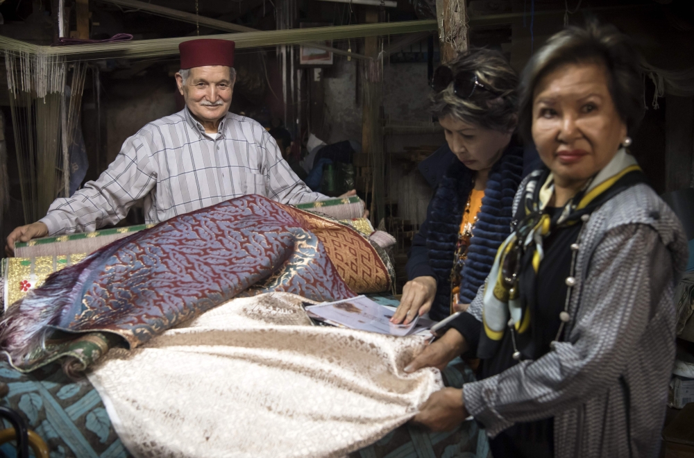 Abdelkader Ouazzani, the last of Morocco's brocade master weavers, displays tapestry at his workshop in the old city of Fes on April 10, 2019.  AFP / Fadel Senna 
