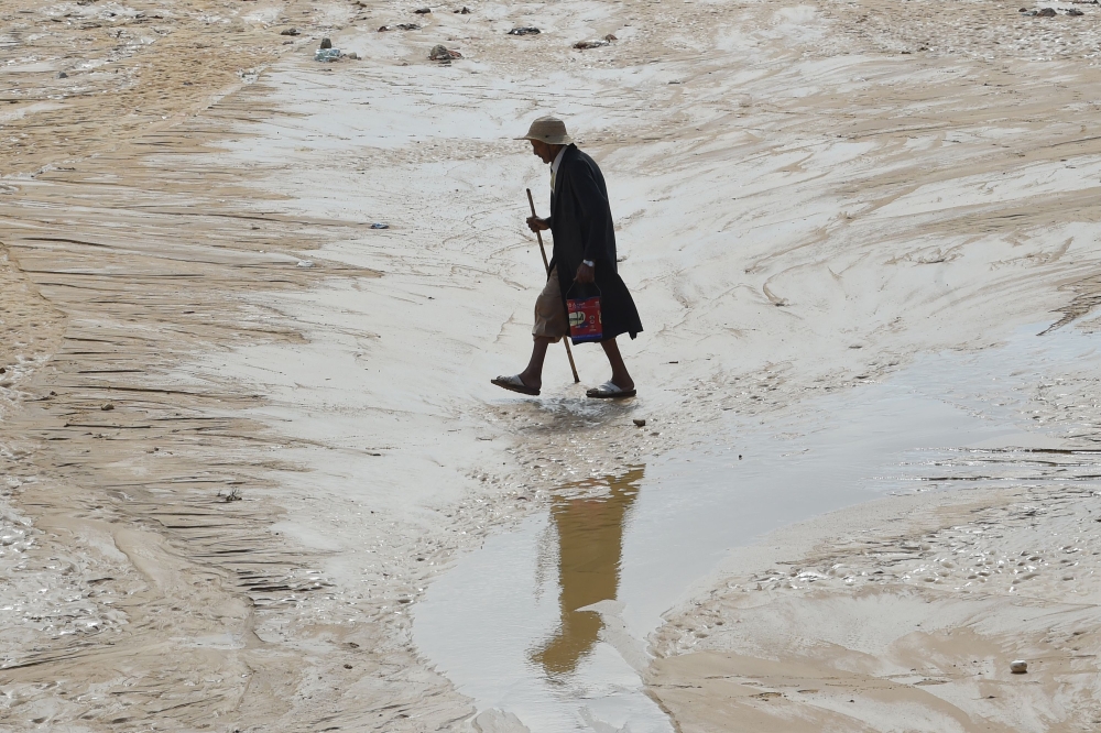 A man walks in a flooded road in the Tunisian coastal governorate of Nabeul on September 23, 2018 following deadly flash flooding in the town of Bir Challouf. AFP/Fethi Belaid
