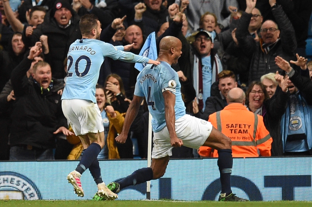 Manchester City's Belgian defender Vincent Kompany (R) celebrates scoring the opening goal during the English Premier League football match between Manchester City and Leicester City at the Etihad Stadium in Manchester, north west England, on May 6, 2019.