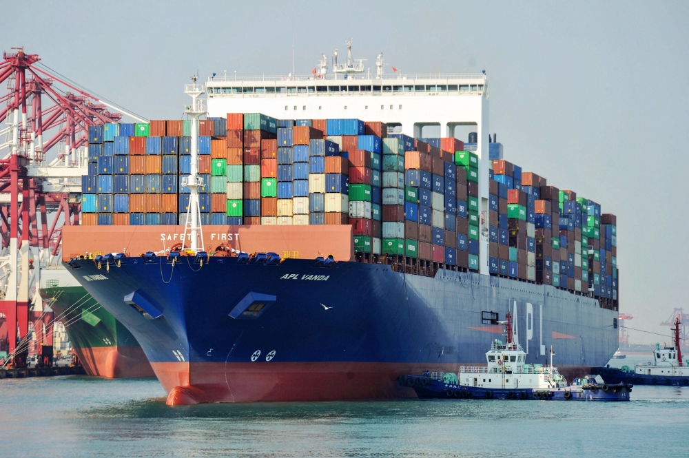 FILE PHOTO: A US cargo ship berthing at a port in Qingdao in China's eastern Shandong province.  China OUT / AFP 