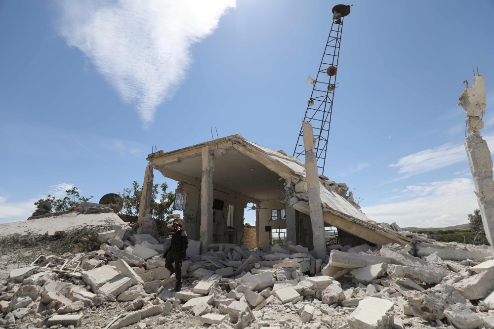 A member of the Syrian Civil Defence (White Helmets) inspect the rubble following shelling by Syrian regime forces and their allies on a the village of Maarit Sin in the countryside of the rebel-held Idlib province on May 11, 2019. / AFP / OMAR HAJ KADOUR