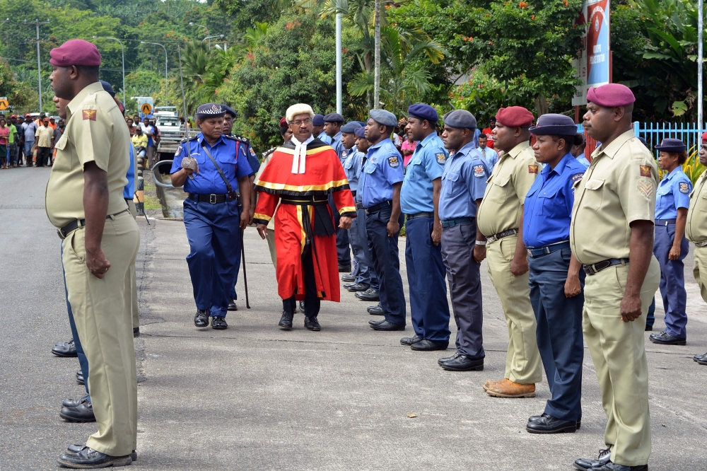 This picture taken on March 4, 2019 shows parade commander Julie Palakai (L) escorting East New Britain’s new residential Judge Justice Stephen Kassman (R) during a guard of honour parade outside Kokopo Police station in Kokopo, Papua New Guinea. AFP / El
