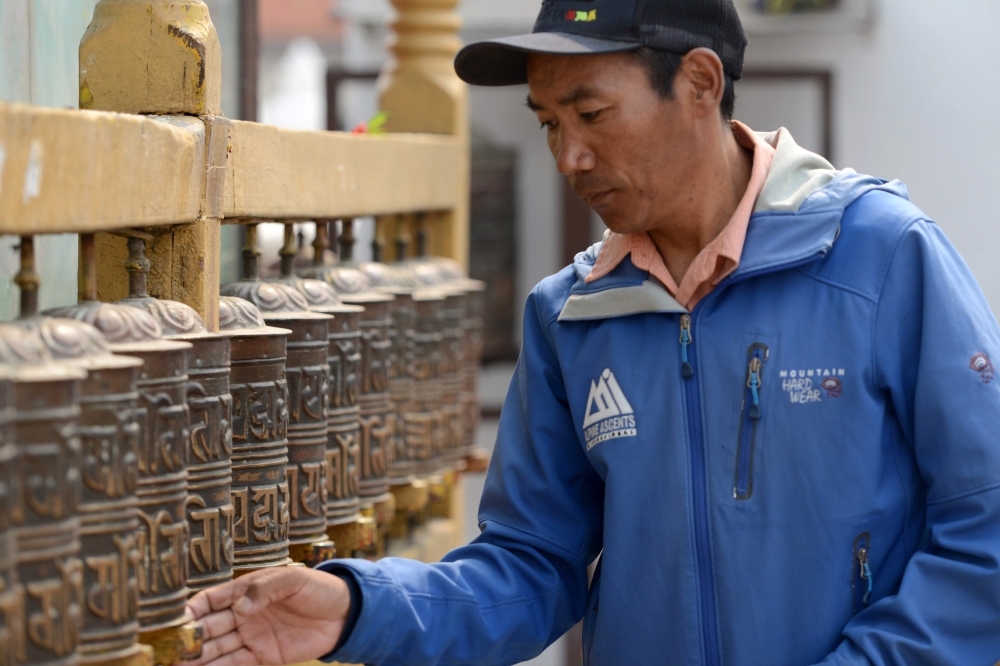 In this file photo taken on March 28, 2018, Nepali mountaineer Kami Rita Sherpa spins prayer wheels at Boudhanath Stupa on the outskirts of Kathmandu. AFP / Prakash Mathema 