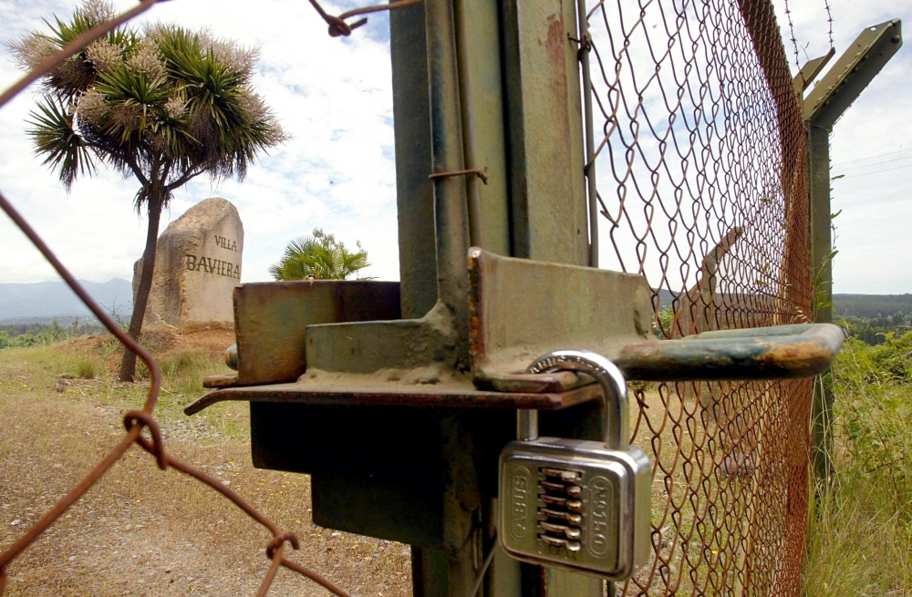 Locked gate of the former entrance to Villa Baviera - formerly known as Colonia Dignidad (Dignity Colony), some 350 km south of Santiago on November 22, 2004.  AFP / Luis Hidalgo 