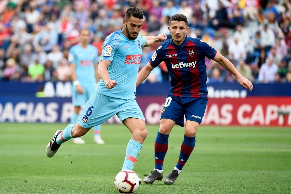 Atletico Madrid's Spanish midfielder Koke (L) challenges Levante's Macedonian midfielder Enis Bardhi during the Spanish League football match between Levante and Atletico Madrid at the Ciutat de Valencia stadium in Valencia on May 18, 2019. / AFP / JOSE J