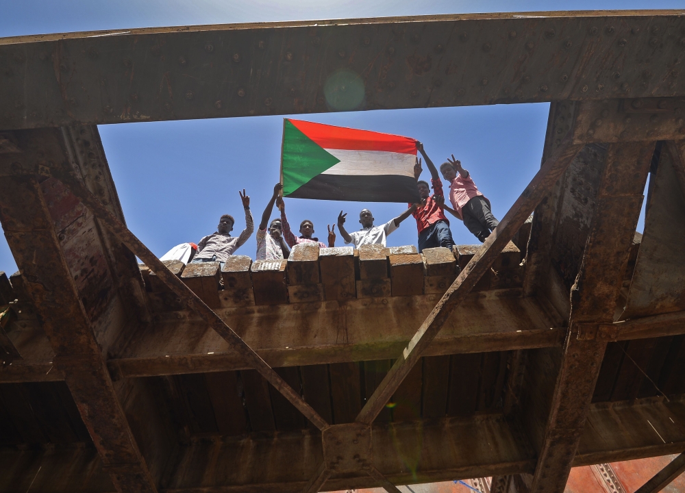 Sudanese protesters wave a national flag near the military headquarters in the capital Khartoum on May 17, 2019, during an ongoing sit-in demanding a civilian-led government transition. AFP / MOHAMED EL-SHAHED