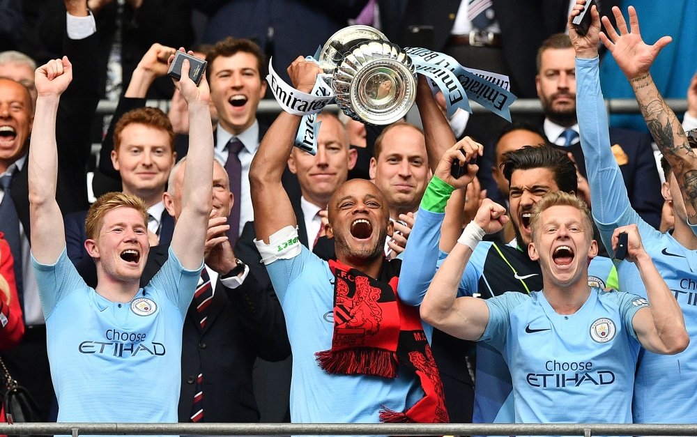 Manchester City's Belgian captain Vincent Kompany (C) lifts the winner's trophy as the players celebrate victory after the English FA Cup final football match between Manchester City and Watford at Wembley Stadium in London, on May 18, 2019.  AFP / Daniel