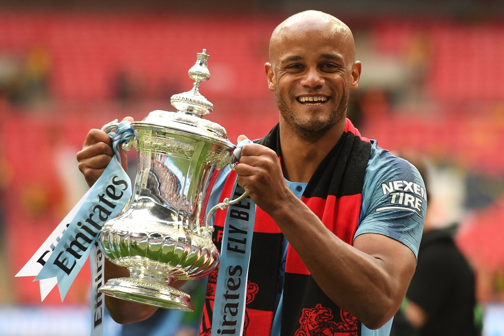 Manchester City's Belgian captain Vincent Kompany holds the winner's trophy after the English FA Cup final football match between Manchester City and Watford at Wembley Stadium in London, on May 18, 2019. AFP / Daniel Leal-Olivas 