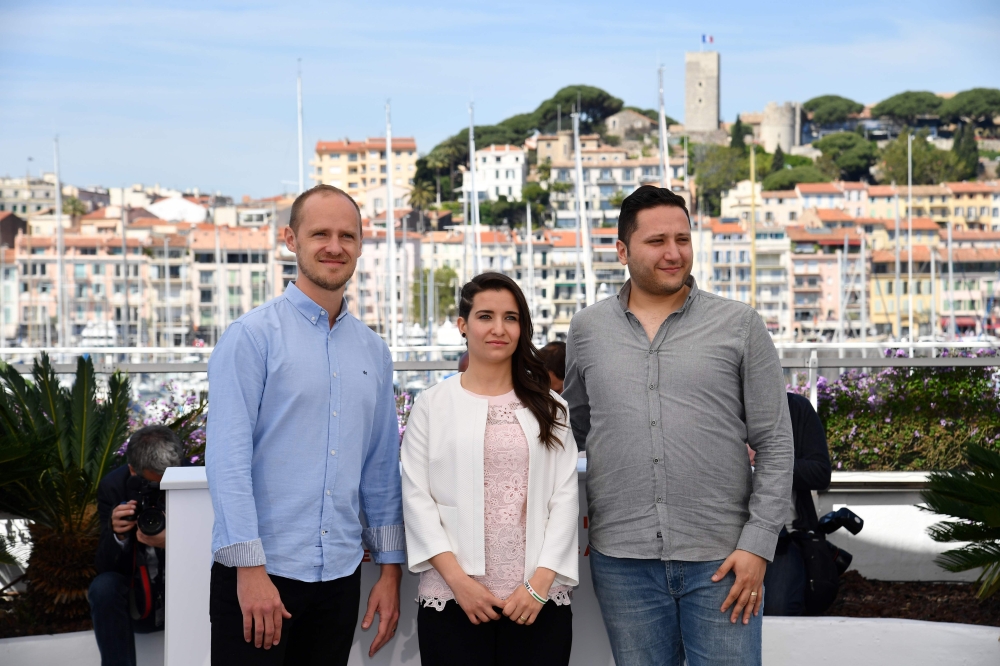 British director Edward Watts, Syrian director and producer Waad al-Kateab and Syrian actor Hamza al-Kateab pose during a photocall for the film 