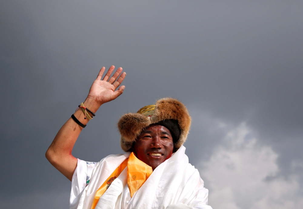 FILE PHOTO: Kami Rita Sherpa, 48, a Nepali mountaineer waves towards the media personnel upon his arrival after climbing Mount Everest for a 22nd time, creating a new record for the most summits of the world's highest mountain, in Kathmandu, Nepal May 20,