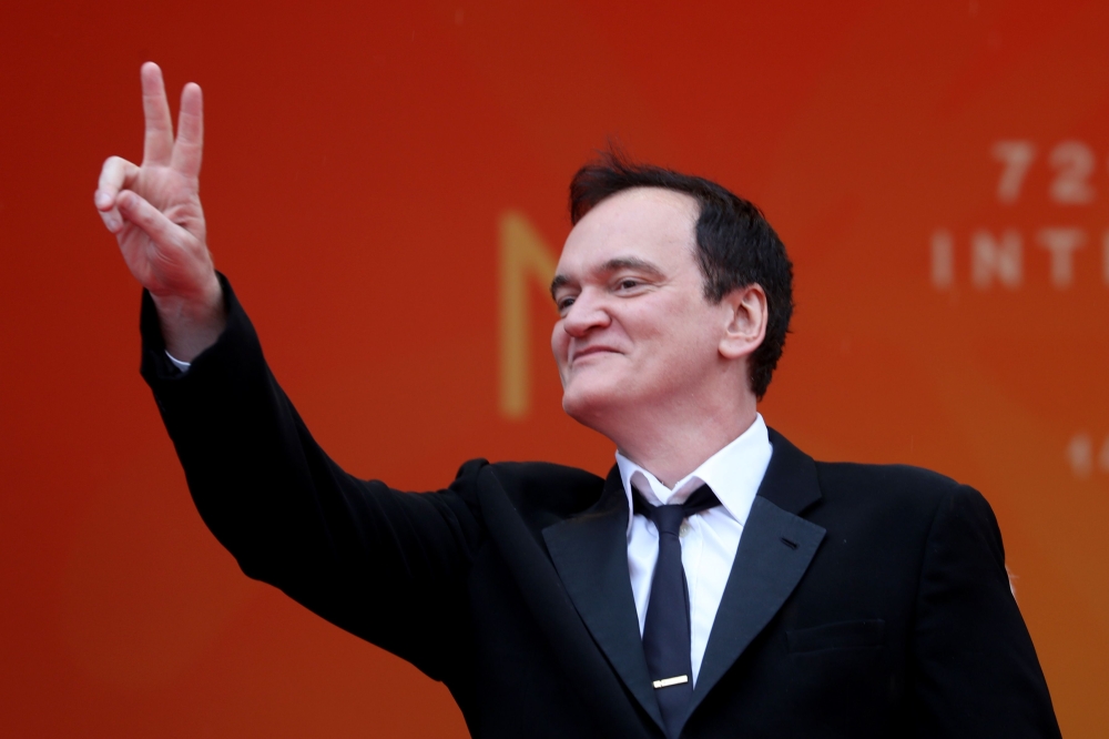 US film director Quentin Tarantino flashes the victory sign as he arrives for the screening of the film 