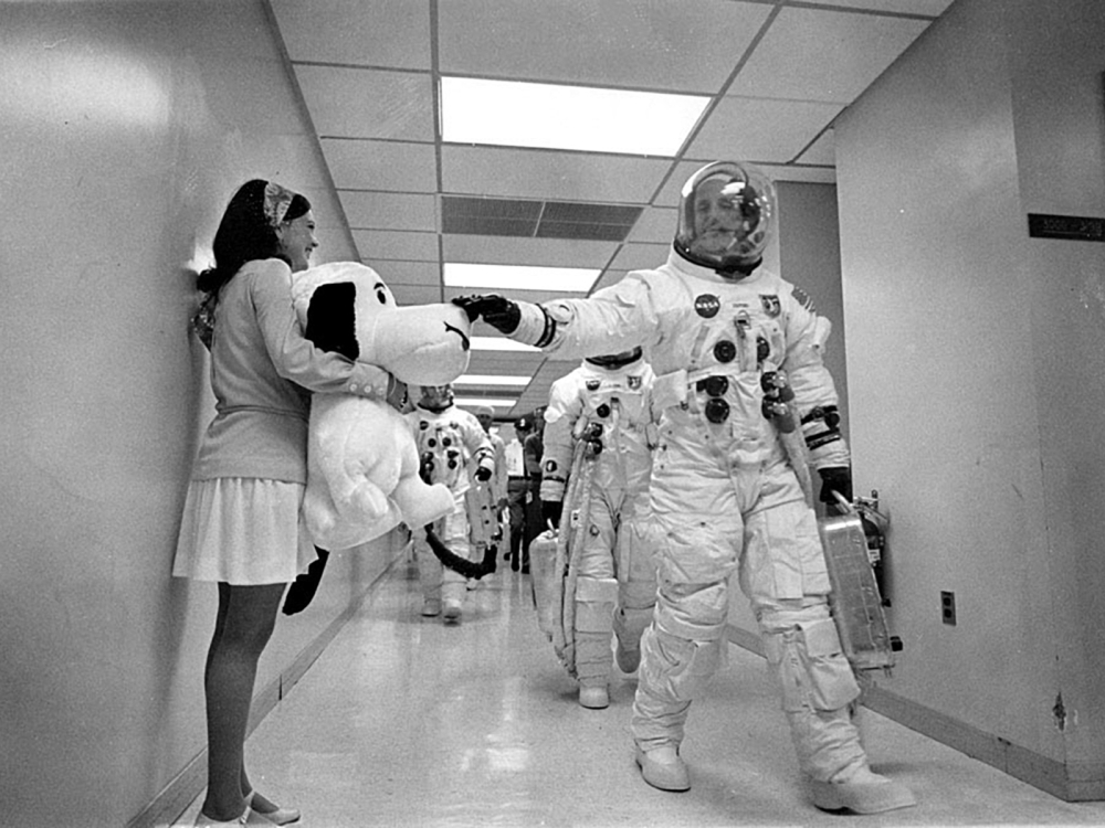 In this May 18, 1969 image obtained from NASA, Apollo 10 Commander Tom Stafford, heading to the Kennedy Space Center launch pad, pats the nose of a stuffed Snoopy held by Jamye Flowers (Coplin), astronaut Gordon Cooper’s secretary.