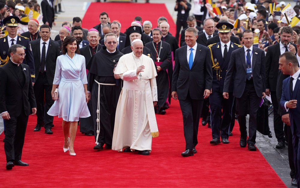 Pope Francis (C) is welcomed by Romania's President Klaus Iohannis (C-L) and his wife Carmen Iohannis (C-L) after arriving at the Henri Coanda airport in Bucharest on May 31, 2019.  AFP / Andrei PUNGOVSCHI 