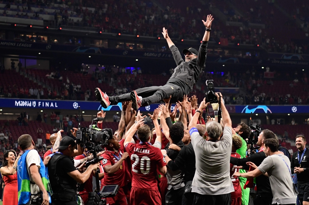 Liverpool's players throw German manager Jurgen Klopp (C) in the air after winning the UEFA Champions League final football match between Liverpool and Tottenham Hotspur at the Wanda Metropolitano Stadium in Madrid on June 1, 2019. / AFP / JAVIER SORIANO